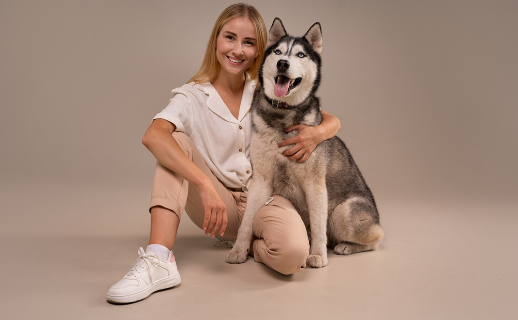 Happy woman posing with husky dog